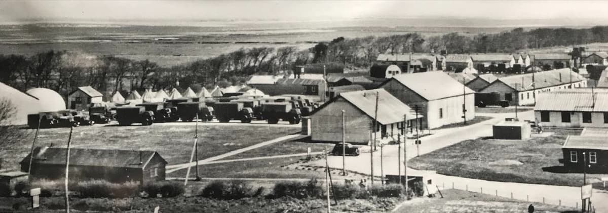 The army anti-aircraft training camp: rows of army lorries, Nissen huts and camp buildings, with the salt marsh and sea beyond