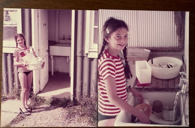 A girl in a striped top carrying washing-up past the old corrugated-iron wash-house, and washing up at its outdoor sink